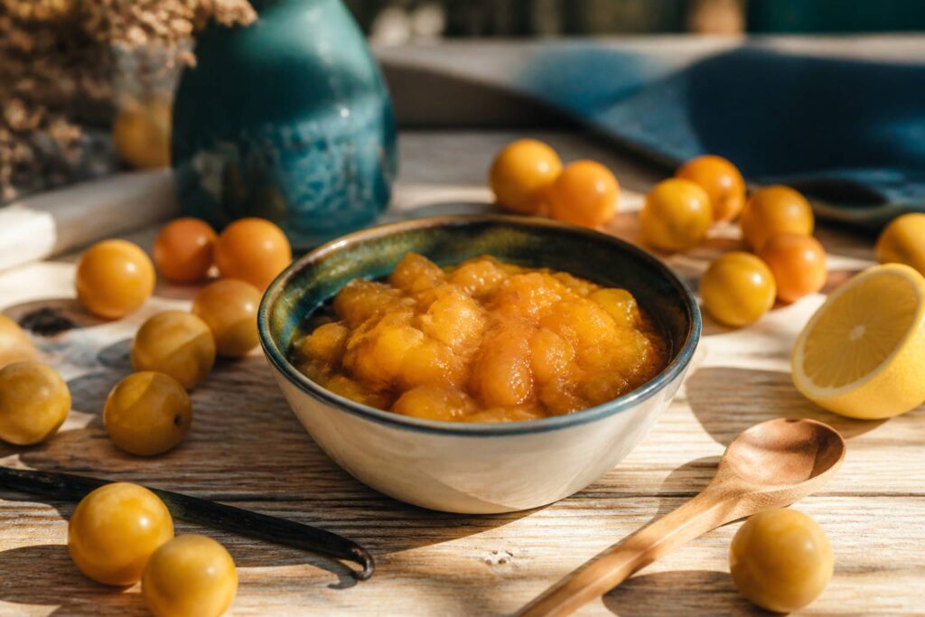 Bol de compote de mirabelles dorée avec des mirabelles fraîches