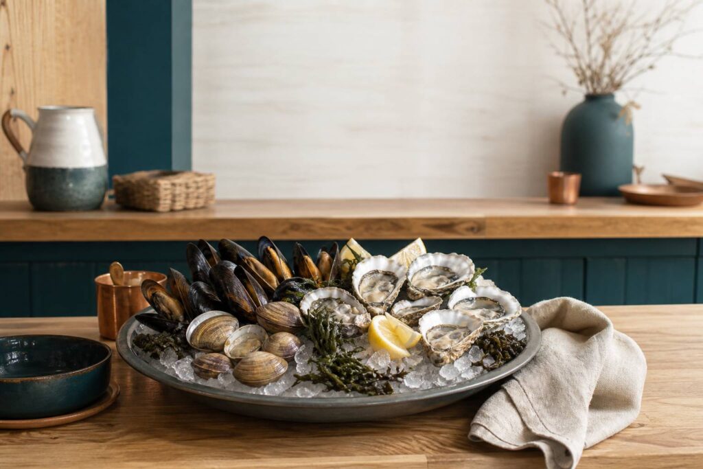 Plateau de coquillages frais — moules, huîtres et palourdes — sur lit de glace dans un bistrot lumineux