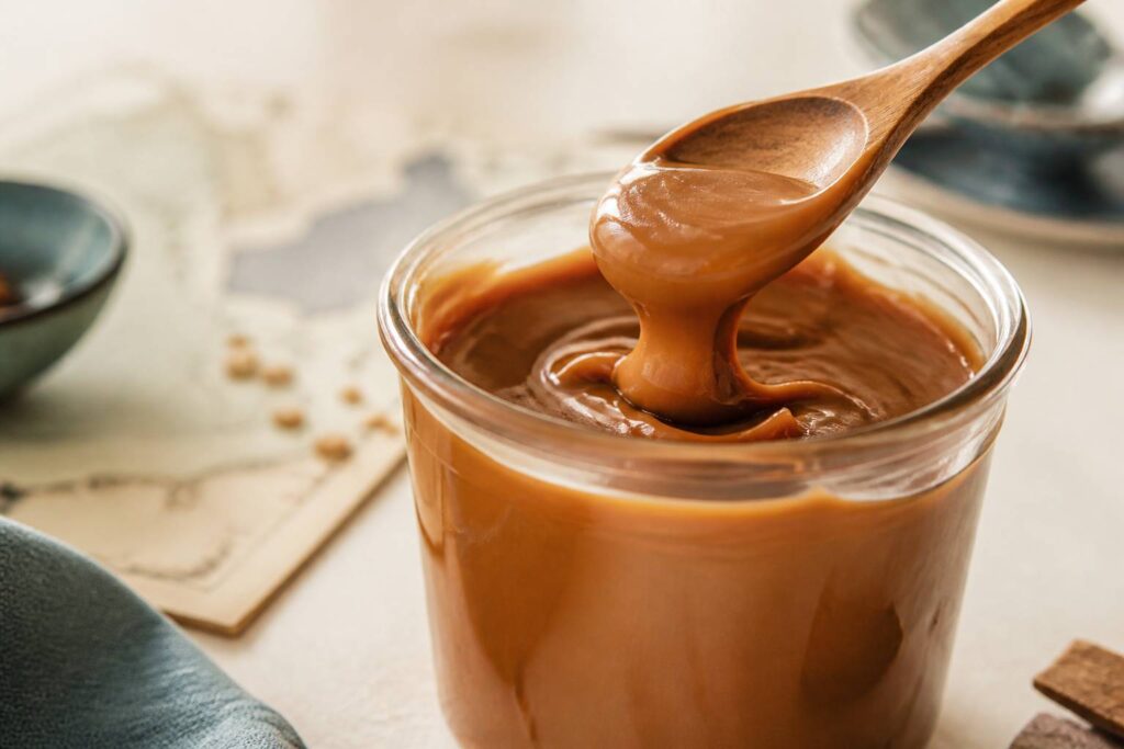 Pot de dulce de leche caramélisé avec une cuillère en bois